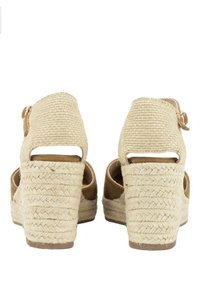 Sandalias de cuña con un upper similar al yute y acentos de ante en tono marrón. Diseño de tacón abierto, textura tejida y un tacón ligeramente texturizado.