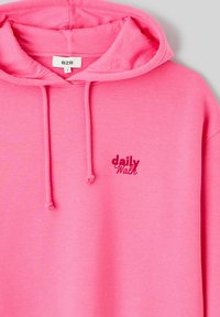 Sweat à capuche rose en tissu doux, doté d'une capuche à cordon et du texte brodé "daily Walk" en rose foncé. Design simple sans motifs.