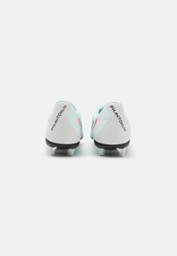 Des crampons de football présentant un dessus synthétique bleu clair, une semelle extérieure noire et des accents roses. La vue arrière montre le logo et une forme épurée.