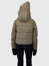 Pessoa vestindo uma jaqueta puffer bege com capuz, um gorro de malha bege, luvas pretas e calças pretas, virada de costas contra um fundo plain.