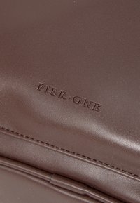 Brown leather, embossed "PIER·ONE" logo, smooth texture with subtle sheen, edge stitching visible, rectangular shape, minimalistic design.