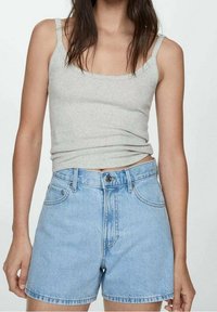 Débardeur gris ajusté et short en denim bleu taille haute. Le tissu semble lisse, avec une coupe classique et un minimum de matériel.