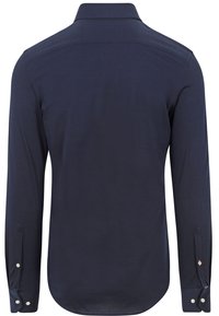 Marineblauwe blouse met lange mouwen van textuurstof, met knoopmanchetten en een klassieke kraag. Beschikt over een gebogen zoom en subtiele tonale stiknaden.