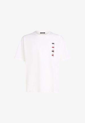 Hvid bomulds t-shirt med rund halsudskæring, der præsenterer fire stiliserede grafiske designs af ansigtet med forskellige solbriller på venstre side.