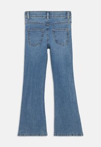 Jeans in denim blu a gamba svasata con vita media, due tasche posteriori e una consistenza morbida. Il tessuto presenta una leggera scoloritura con cuciture visibili.