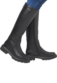 Schwarze knöchelhohe Stiefel aus glattem Leder mit einem seitlichen Reißverschluss, dicken Gummisohlen und subtilen Stitching-Details entlang des Designs.