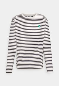 Långärmad skjorta i krämfärg med marinblå ränder. Har en rund halsringning och en liten grön logotyp på bröstet. Mjuk bomullstextur.