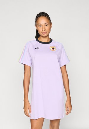 Fliederfarbenes T-Shirt-Kleid mit Rundhalsausschnitt, kurzen Ärmeln und schwarzen Akzenten. Mit einem Logo auf der Brust und mehrfarbigen Streifen entlang der Ärmel.