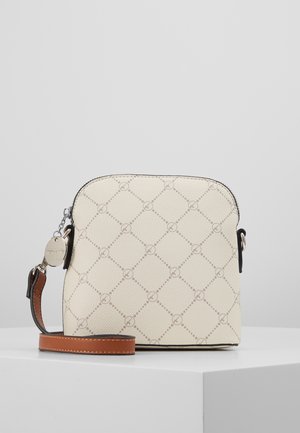 Petit sac bandoulière beige avec une sangle marron et un pendentif logo circulaire argenté, avec un motif losange subtil sur la surface.