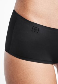 Svarta boxerkalsonger i stretchigt tyg, med en jämn yta och en diskret logotyp i midjebandet. Tajt passform.