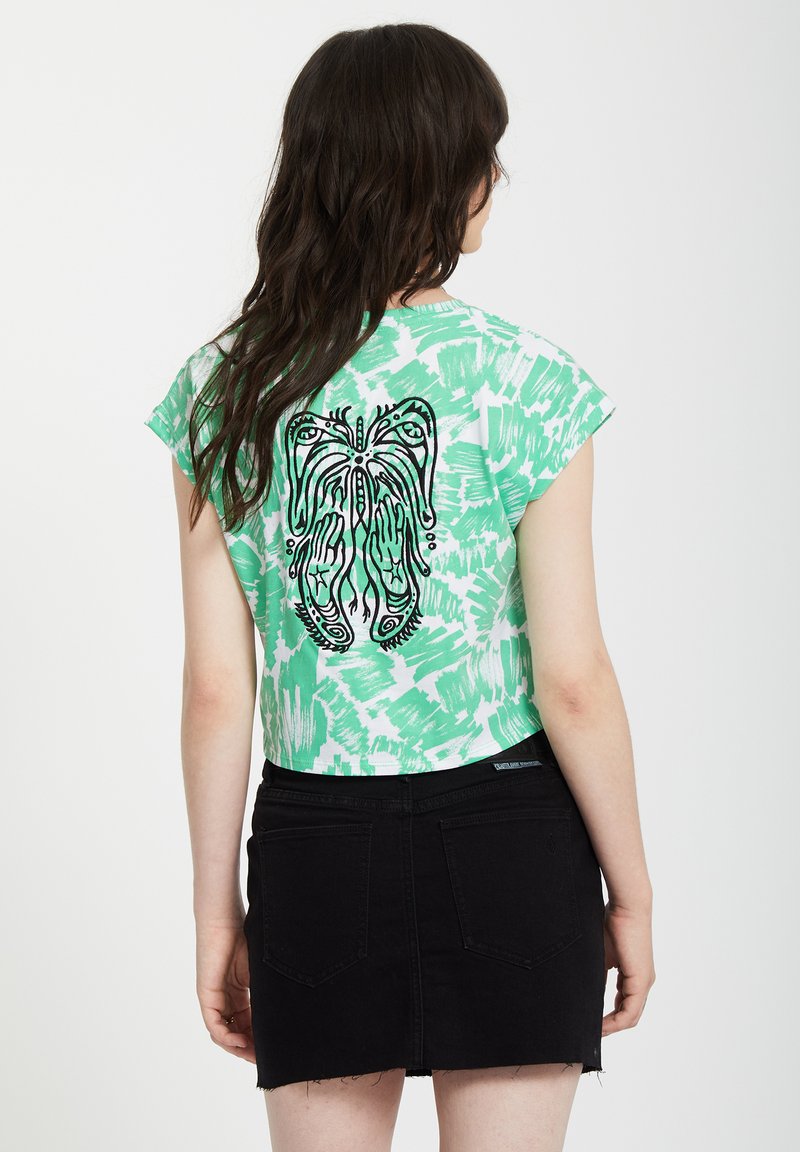 Groene tie-dye cropped t-shirt met zwarte grafische print van een vlinder en handen op de achterkant, gecombineerd met een zwarte denim minirok.