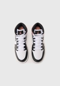 Sneaker alte con un design in pelle bianca e nera, punta perforata, dettagli neri, lacci bianchi e un logo rosa sulla linguetta.