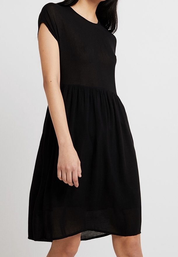 Schwarzes, kurzärmliges Kleid mit rundem Ausschnitt und locker fließendem Rock. Hergestellt aus einem leichten Stoff, zeichnet sich durch ein einfaches, klassisches Design aus.