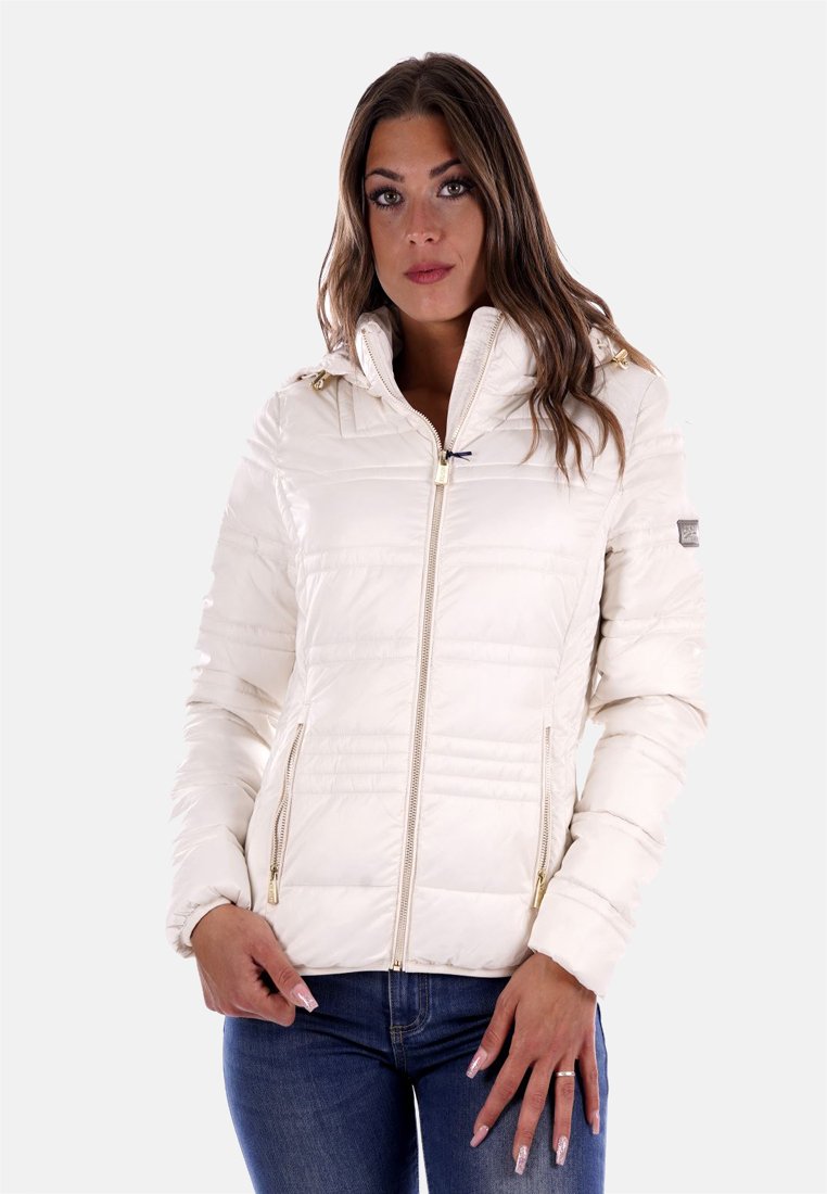 Giacca imbottita di colore crema con cappuccio, chiusura con zip e dettagli in metallo dorato. Presenta una texture trapuntata e due tasche laterali con zip.