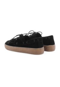 Schwarze Wildlederschuhe mit einer Gummisohle, Schnürsystem und Metallösen; entworfen mit einem flachen Profil und strukturierten Details.