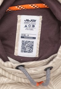 Beige en bruine gestreepte hoodie binnenkant met een label, oranje trekkoord, zwarte ritsaccents, en QR-code.