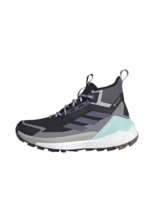 Zapato de senderismo alto en negro y gris con suela blanca, cordones morados, tiradores y soporte para el talón en azul claro, con marcas Gore-Tex y Terrex.
