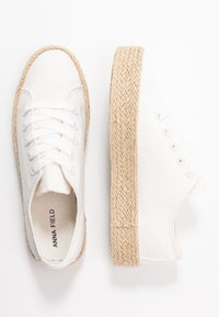 Sneakers bianchi in tela con suola piatta in juta intrecciata. Design con lacci e occhielli in metallo, e dettaglio della superficie testurizzata.
