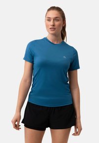 Kurzärmliges Sportshirt in strahlendem Blau, aus feuchtigkeitsableitendem Stoff, kombiniert mit schwarzen Sportshorts für einen eleganten Look.