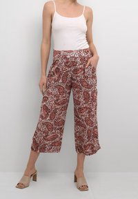 Culottes à motif paisley rouge et blanc avec une taille élastique, dotées de poches latérales et d'une coupe large et décontractée. Fabriquées en tissu léger.