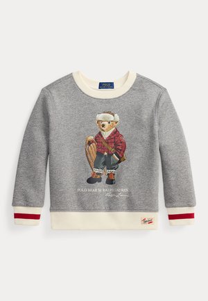Sweat-shirt gris avec un ours illustré portant une chemise à carreaux, tenant une luge. Poignets crème avec des accents rouges. Logo Ralph Lauren à l'ourlet.
