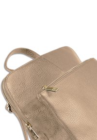 Metalen gouden leren tas met een gestructureerd oppervlak, voorzien van een bovenste ritssluiting en een klein handvat.
