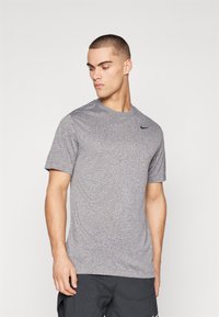Herren-T-Shirt mit kurzen Ärmeln aus meliertem Grau. Es verfügt über einen runden Ausschnitt und ein kleines schwarzes Nike-Logo auf der linken Brust.
