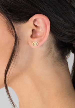 Goldfarbene Ohrringe mit einem kreisförmigen Design, das einen strukturierten Ring und einen Cluster aus klaren Edelsteinen beinhaltet. Glatte Oberfläche mit glänzenden Akzenten.