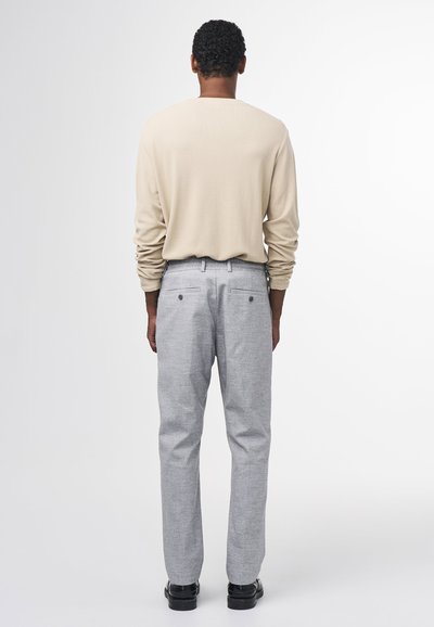 Beige long-sleeve shirt paired with light gray trousers. Trousers have two back pockets, simple design, and straight leg fit. Black shoes.