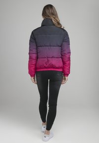 Bunda s kapucí s gradientem od černé po růžovou, prošívaný design, vysoký límec a elastické manžety. Nosit s černými skinny džínami.