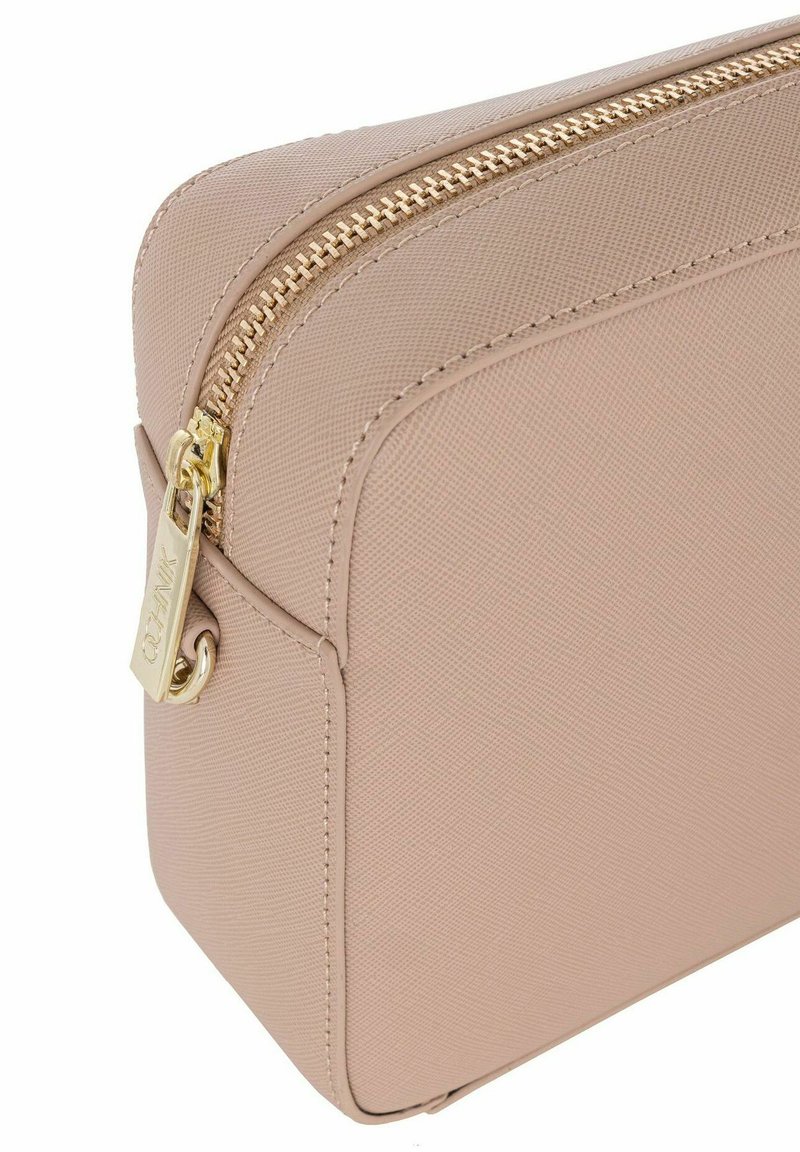 Neceser de cosméticos texturizado en color beige con un cierre dorado. Presenta una forma rectangular y un pequeño lazo lateral para sujeción. Diseño simple.