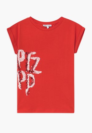 Czerwona bawełniana koszulka z krótkim rękawem, z błyszczącym napisem z czerwonych i białych cekinów z przodu. Okrągły dekolt, luźny krój.