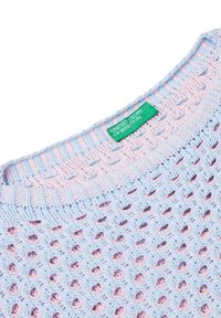 Lekki, dzianinowy sweter w pastelowej kolorystyce niebieskiej i różowej, z geometrycznym otwartym splotem i zieloną metką marki.