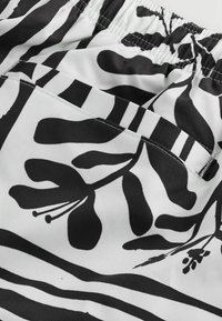 Tessuto a motivo floreale in bianco e nero con tasca cucita e dettaglio di vita elastica.