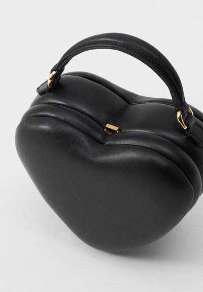 Black leather handbag in heart shape, featuring a structured design, smooth texture, short handle, and gold-tone hardware accent.