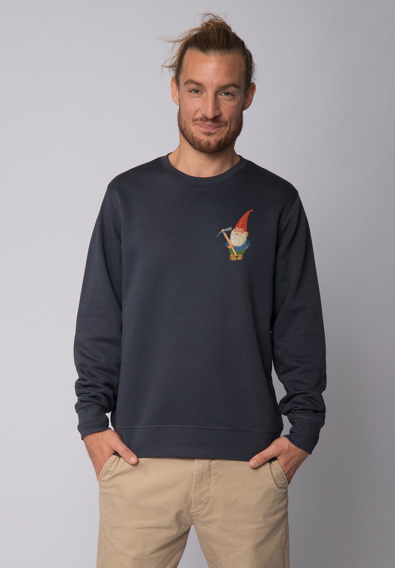 Sweatshirt bleu marine à manches longues, col rond, avec un graphisme de gnome sur le côté gauche de la poitrine. Matériau en mélange de coton avec des poignets côtelés.