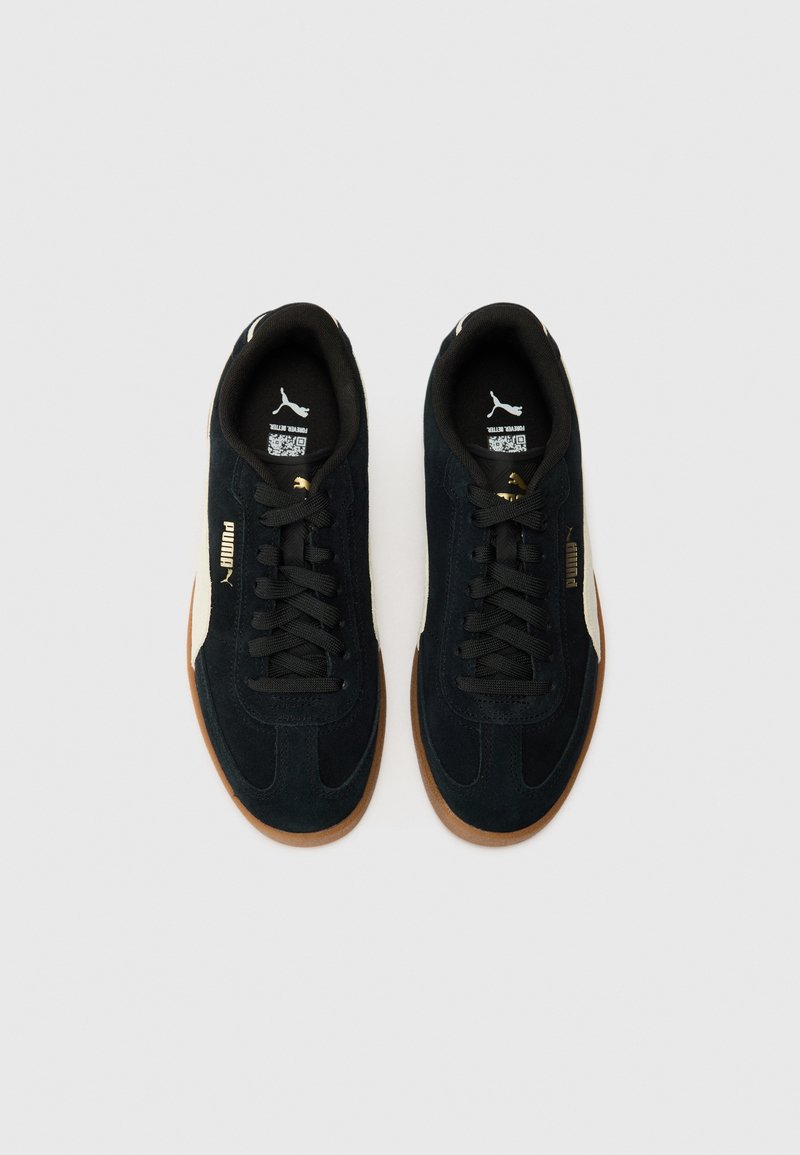 Sneaker in suede nera con suola in gomma, dotate di lacci neri, una striscia laterale bianca e branding dorato. Design con punta rotonda e dettagli minimal.