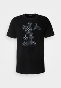 Camiseta de algodón negra con un patrón de tablero de ajedrez de Mickey Mouse en gris y negro, con un texto gráfico impreso abajo.