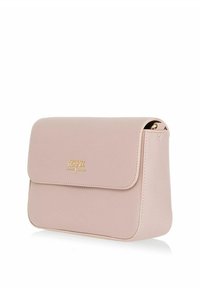 Jasnoróżowa skórzana torebka na ramię z klapką i małym złotym logo CHNIK na środku przodu.
