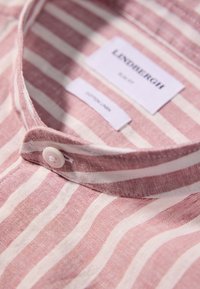 Camicia a righe in cotone-lino rosa e bianco. Presenta una chiusura con bottoni e un colletto classico. L'etichetta riporta la taglia e il materiale.