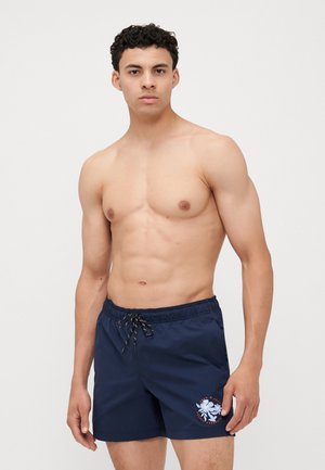 Pantaloni de baie navy dintr-un material ușor, cu talie ajustabilă cu șnur și un design grafic floral pe piciorul stâng.