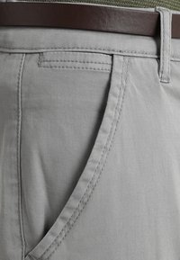 Gray cotton trousers with a smooth texture, featuring a front pocket, stitched detailing, and a brown leather belt at the waist.