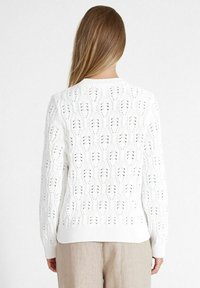 Weißer Strickpullover mit einem Spitzenmuster und gerippten Bündchen. Verfügt über strukturierte Rautenmuster und einen runden Halsausschnitt.