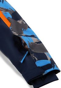 Marineblau gemusterter Jackenärmel mit orangefarbenem Akzent, ausgestattet mit einer Reißverschlusstasche und einem Klettverschluss. Das Material scheint leicht und langlebig zu sein.