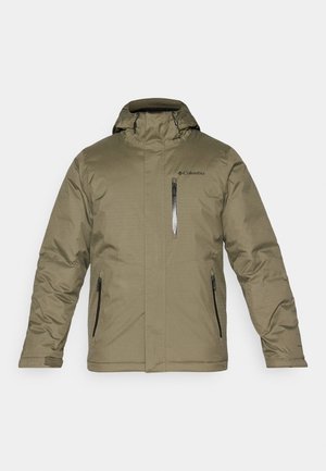 Veste isolée vert olive avec capuche. Dotée d'une fermeture éclair à l'avant et de deux fermetures éclair sur les côtés. Texture lisse et logo Columbia sur la poitrine.