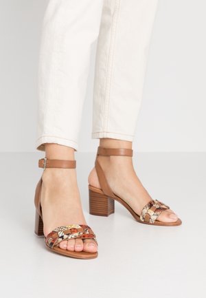 Brązowe skórzane sandały na obcasie z plecionym, wielowzorzystym wierzchem i paskiem na kostkę, z masywnym, teksturowanym obcasem.