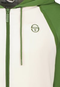 Giacca con cappuccio e zip in verde e bianco. Presenta una zip a tutta lunghezza, dettagli verdi e un logo sul petto. Tessuto morbido.