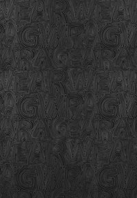 Zwarte textiel met verhoogde, gestructureerde lijnen die de woorden "RAG" en "WEAR" in een herhalend patroon vormen, waardoor een gelaagd visueel effect ontstaat.