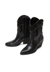 Botas de cowboy de cuero negro con punta afilada, tacón bajo, recortes decorativos y superficies texturizadas. Presentan un acabado suave y una construcción resistente.