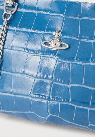 Τσάντα χειρός από μπλε δέρμα με ανάγλυφο μοτίβο κροκοδείλου, με ασημένιο λογότυπο σφαίρας και λεπτομέρεια αλυσίδας στο λουρί.